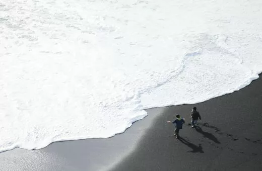 Voyage en famille sur plage sable noir