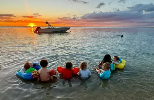 Voyage en famille à l'île maurice enfants dans la mer coucher de soleil